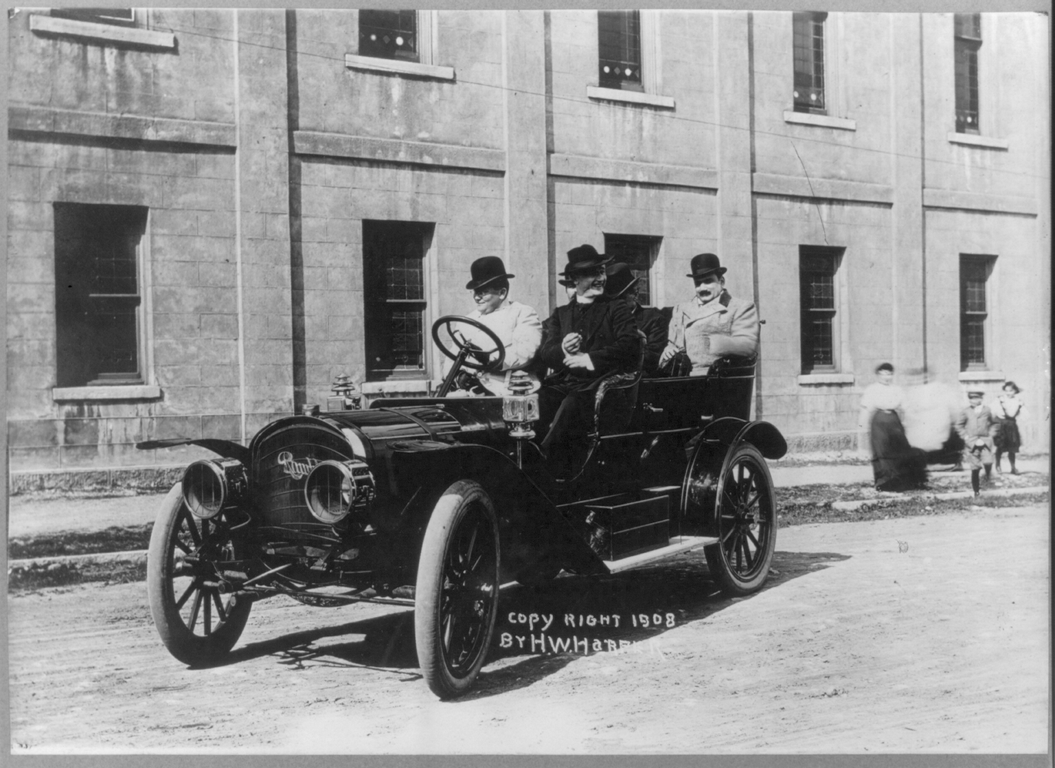 Enrico_Caruso_seated_in_automobile_with_4_other_men.png