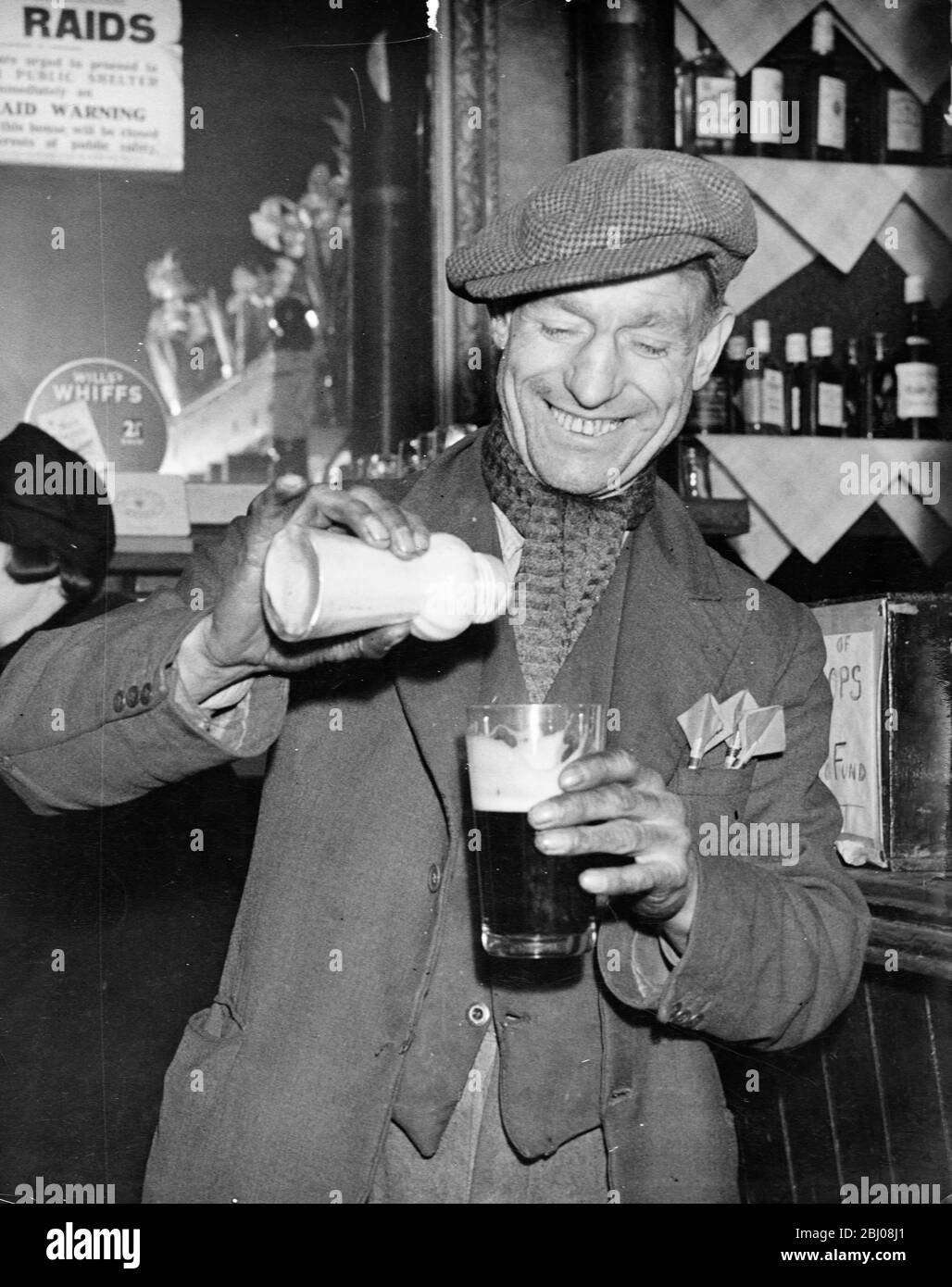 man-pours-ground-ginger-in-his-pint-of-beer-as-practised-by-stevedores-and-dockers-during-cold...jpg