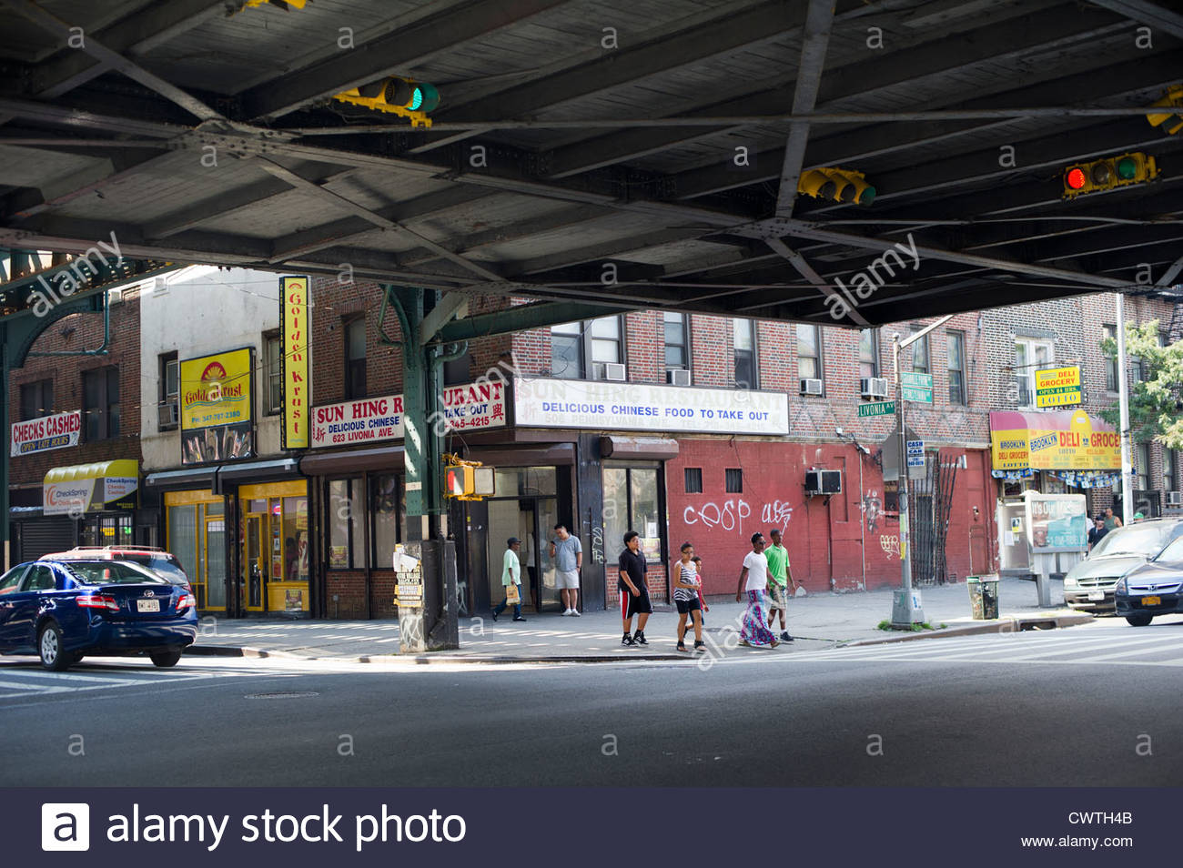 pedestrians-cross-the-street-under-the-elevated-subway-tracks-in-the-CWTH4B.jpg